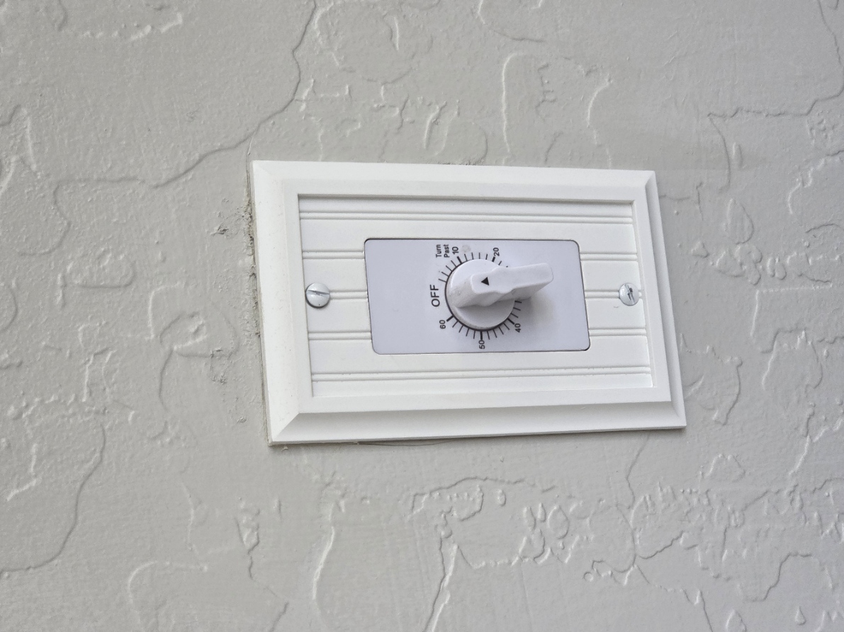 White wall-mounted fireplace timer with an OFF position and numbered time settings.